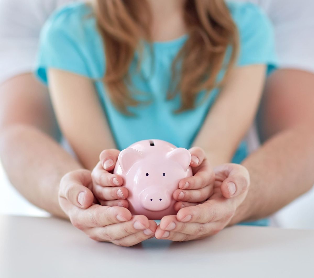 Ein Sparschwein in den Händen eines Kindes